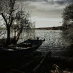 a boat sitting on the shore of a lake